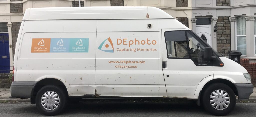 A white transit van branded with “DE photo”.